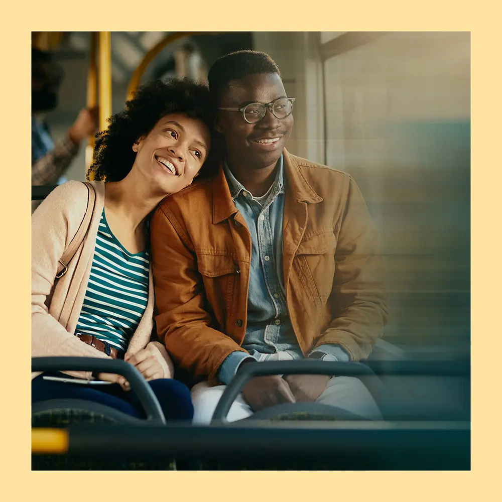 A happy couple riding on bus together