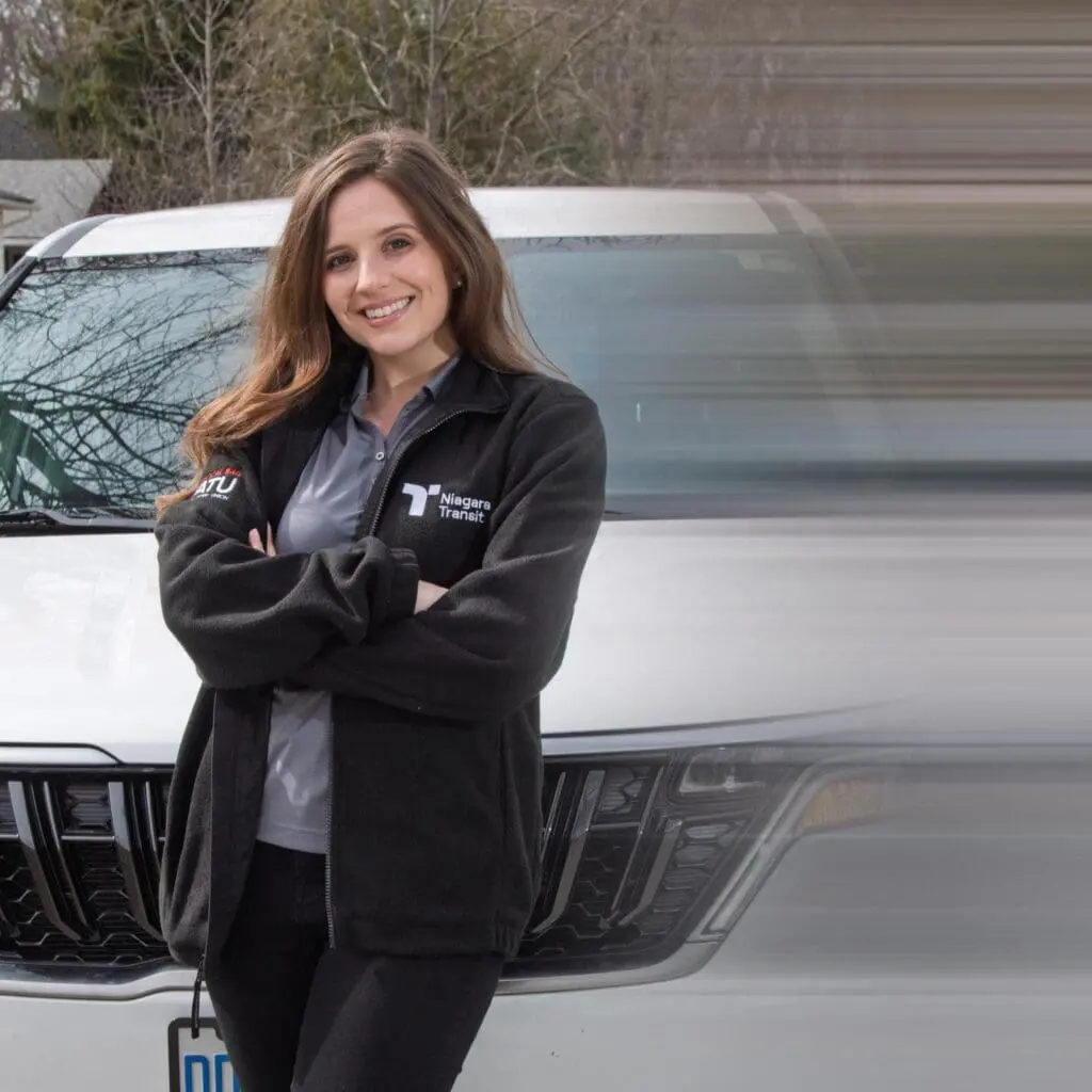 Niagara Transit Plus driver standing in front of vehicle.