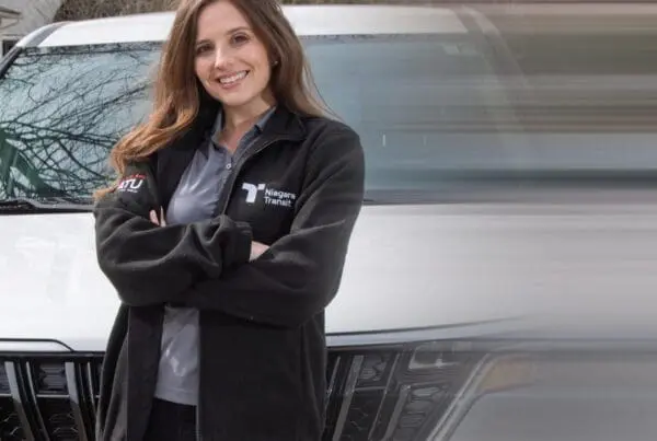 Niagara Transit Plus driver standing in front of vehicle.